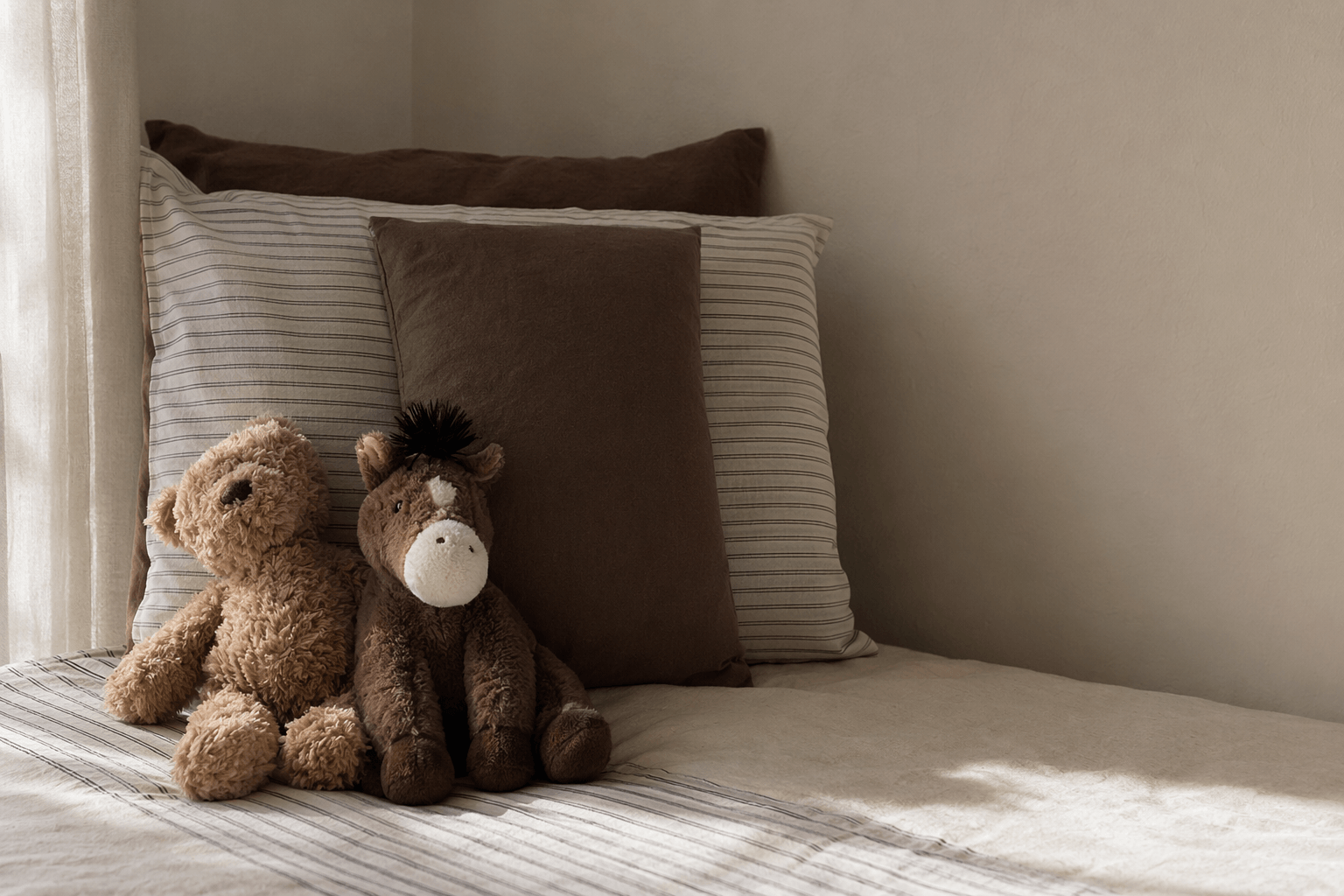 Soft baby textiles in a calm home setting with warm natural light.